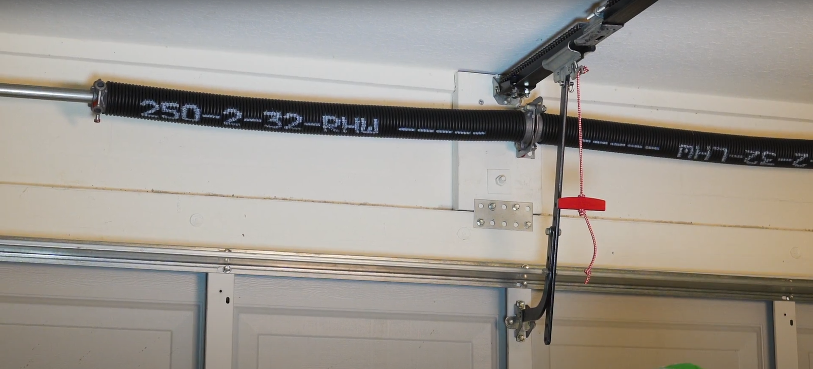 Alt text: Close-up of a technician performing a garage door spring repair.
